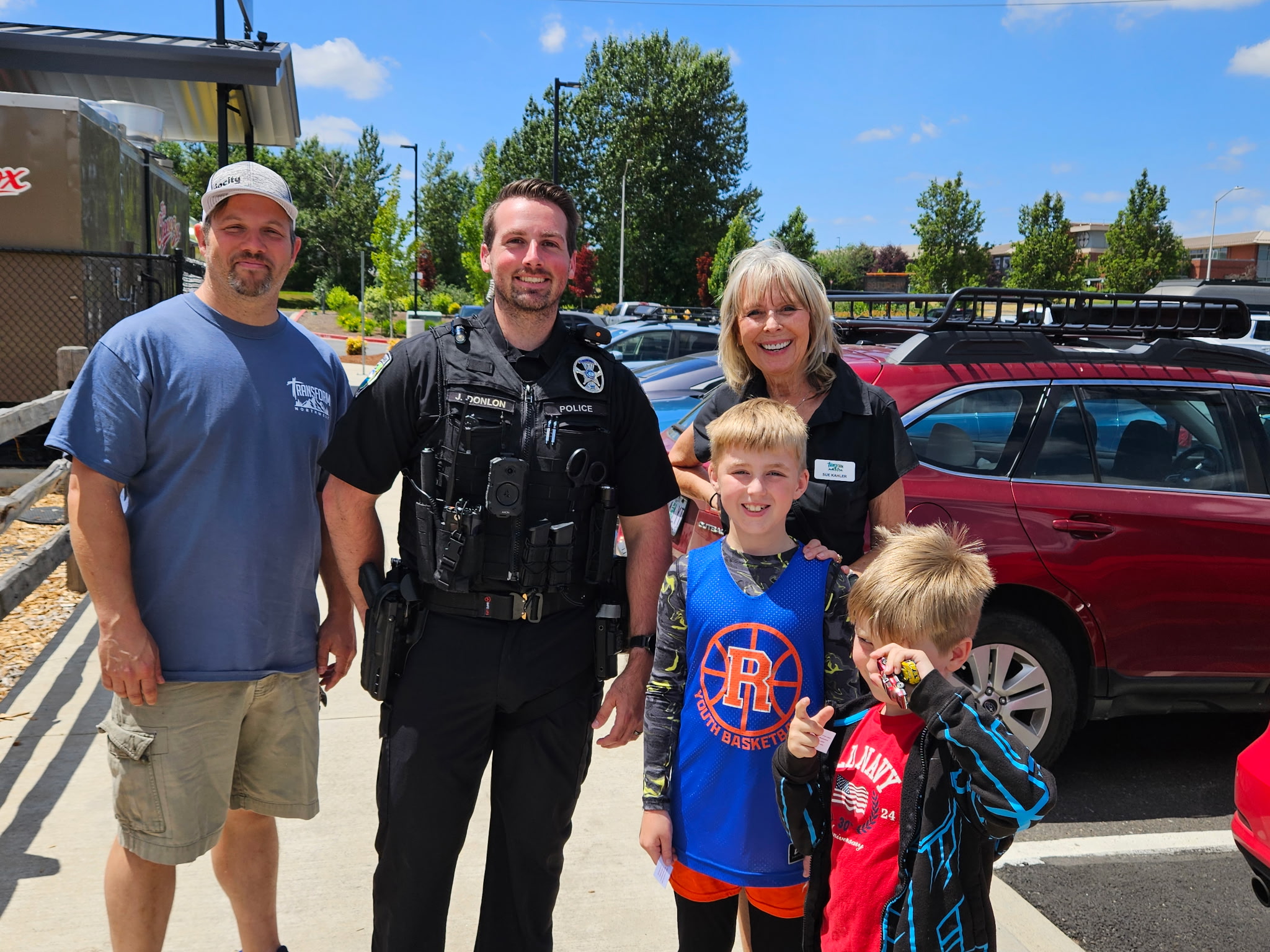 Transform Northwest volunteers, a police officer, and children together at Cops and Cones